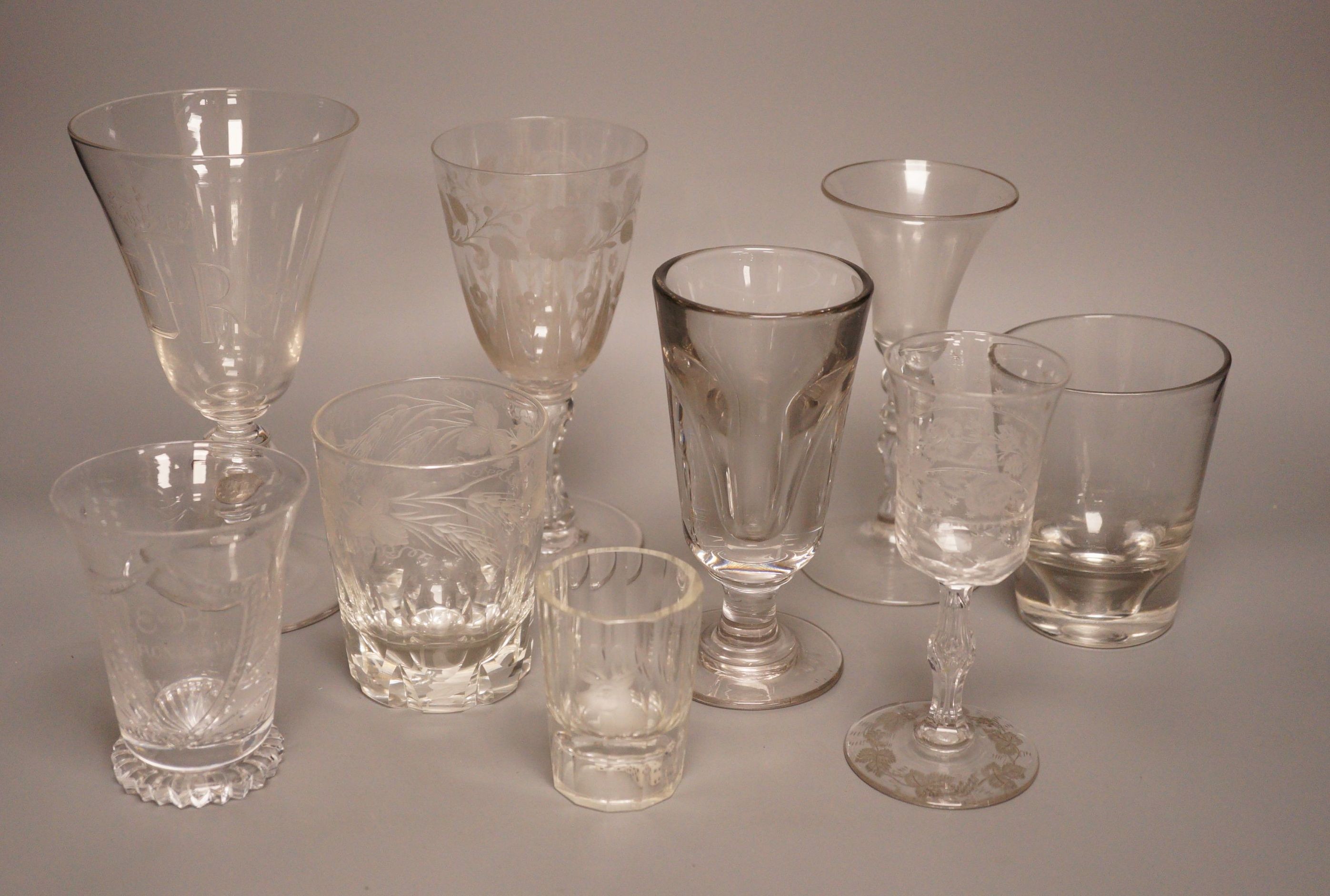 A group of eight 19th/20th century novelty or commemorative glasses, tallest 19.5 cm, including two deceptive glasses, a wheel engraved tumbler with hangman to the base etc.